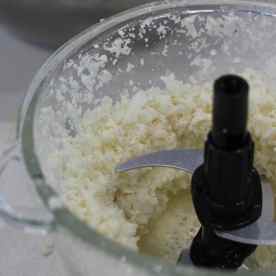 Put the cauliflower heads into a food processor and process it until it resembles fine bread crumbs